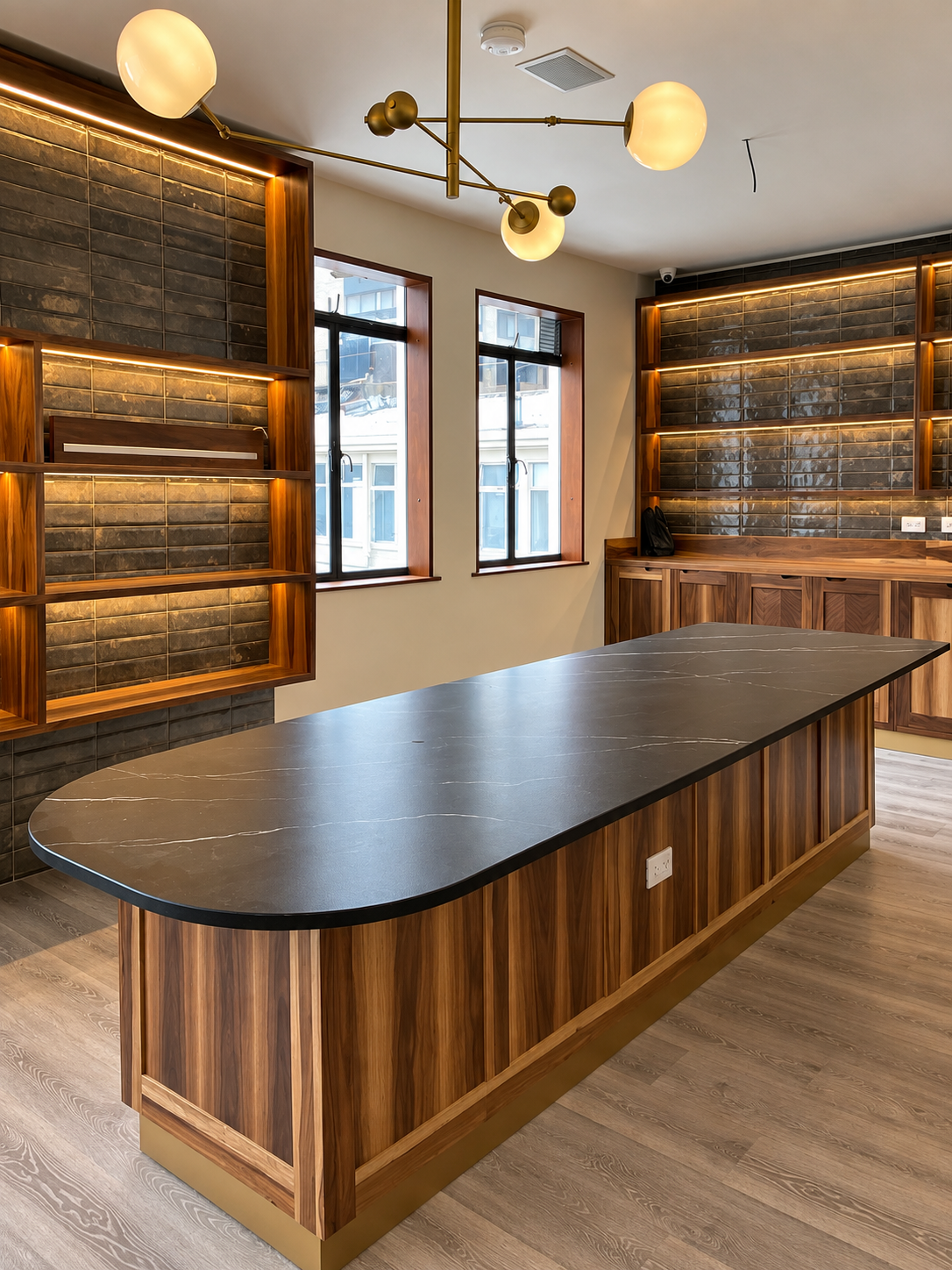 Isla de mobiliario en madera y superficie oscura diseñada por IMB Muebles y Diseños